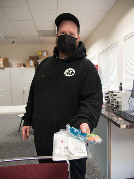 photo of a man issuing a needle exchange kit