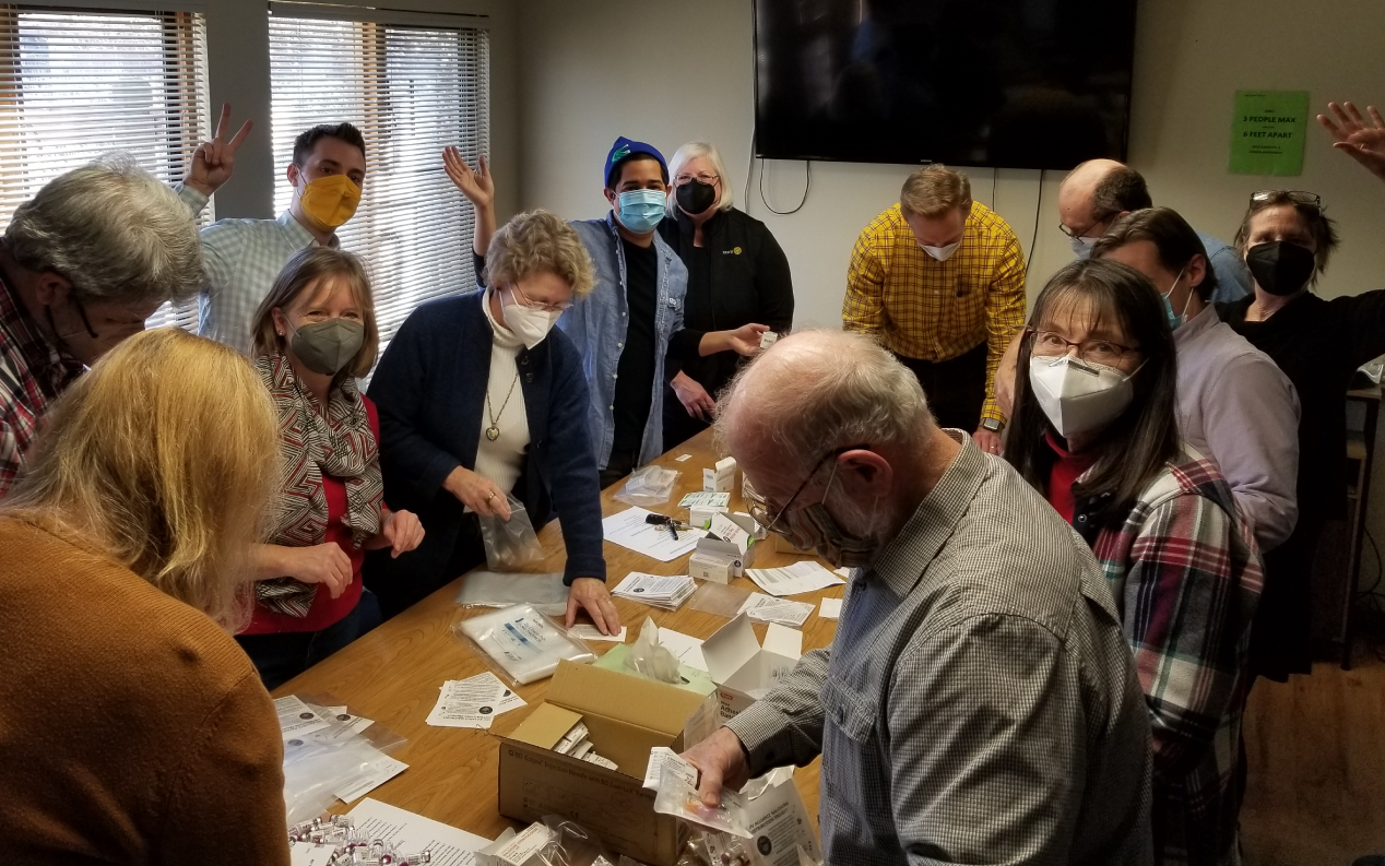 Fotografía de personas preparando kits de intercambio de agujas en apoyo a las oportunidades de voluntariado médico.